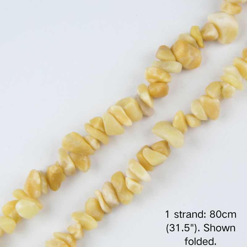 Close-up of 5-8mm creamy natural yellow jade stone chips strung on nylon cord.