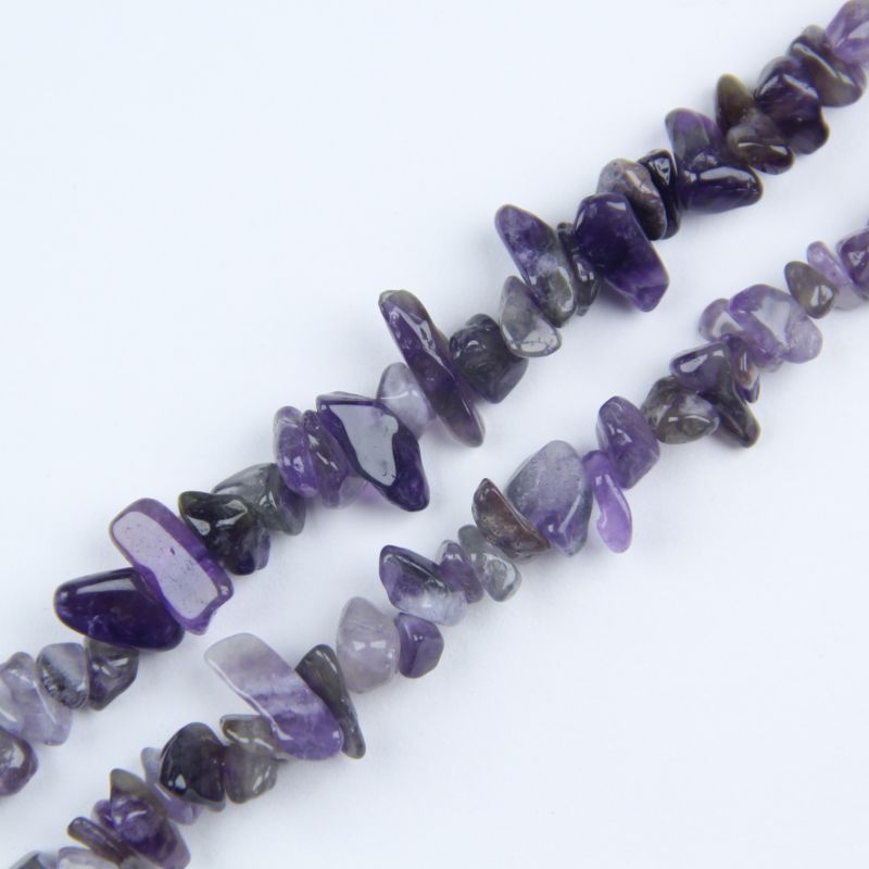 close-up of amethyst irregular round beads showing medium purple color and nylon cord stringing, 5-8mm size