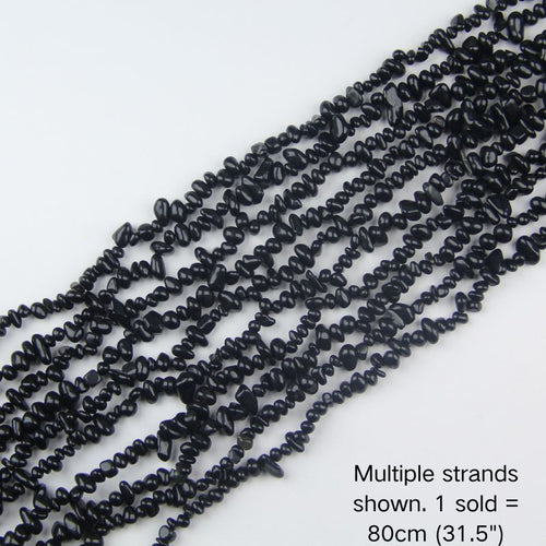 Multiple strands of 31.5" Black Obsidian chip beads (5-8mm) arranged in a row, showing glossy volcanic glass texture for DIY jewelry making.