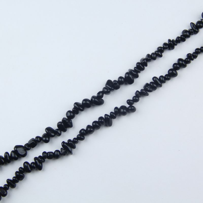 black obsidian long bead chain hanging naturally against white background