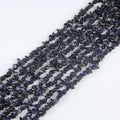 Irregular blue sandstone chip bead long necklace on white background, deep midnight blue glass beads with thousands of tiny copper sparkles visible like stars