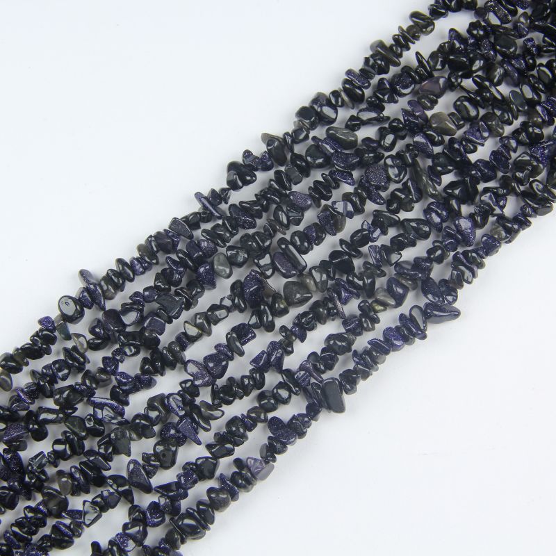 Irregular blue sandstone chip bead long necklace on white background, deep midnight blue glass beads with thousands of tiny copper sparkles visible like stars