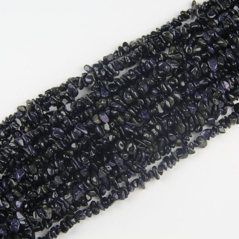 Multiple blue sandstone long necklaces stacked together, showing rich deep blue color and copper glitter sparkles across all strands