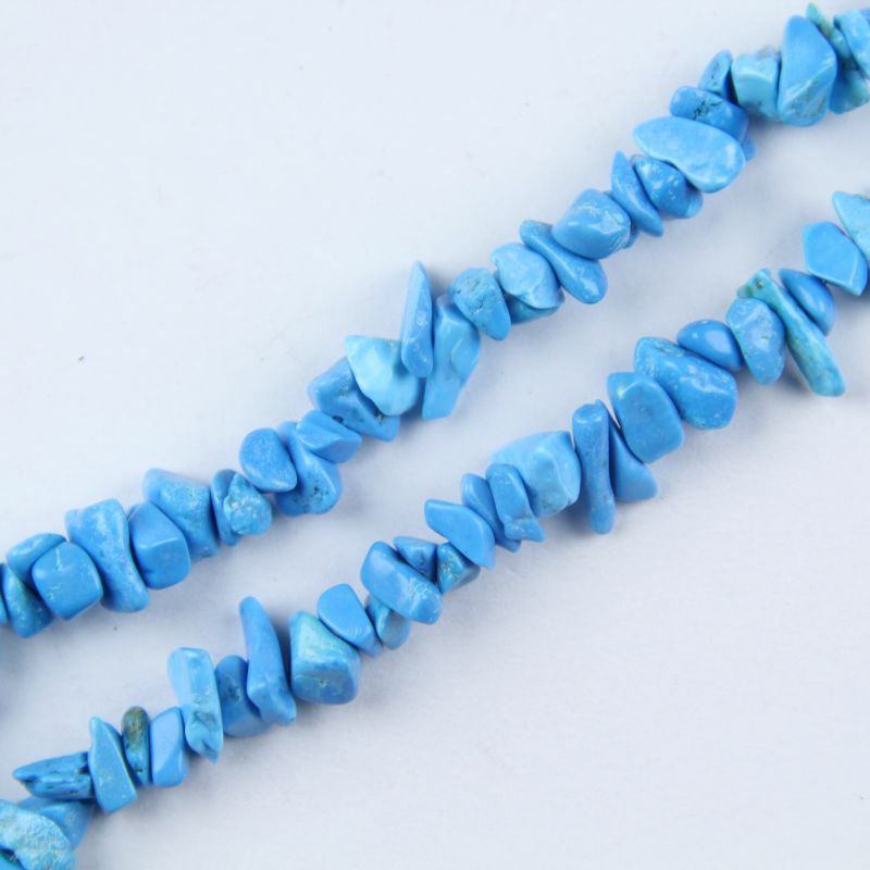 close-up of blue turquoise irregular round beads showing sky-blue color and dark matrix veining with nylon cord stringing, 5-8mm size