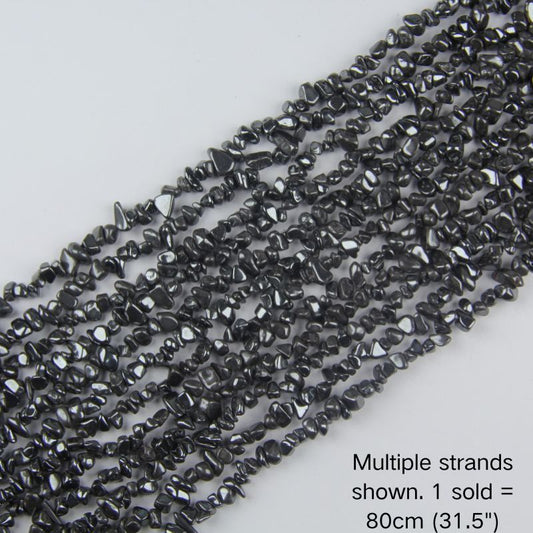Multiple strands of natural black Hematite metallic chip beads laid out flat, each 31.5 inches long and 5-8mm in size, perfect for bulk DIY jewelry making supplies.