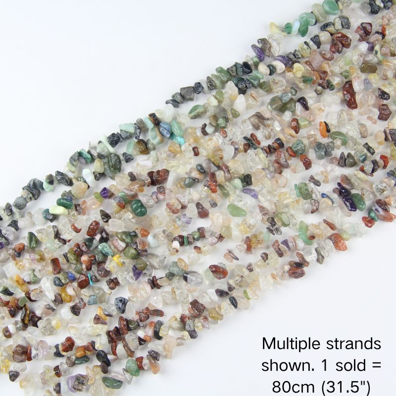 Multiple strands of natural mixed gemstone irregular chip beads laid out flat, 31.5 inches long, featuring a vibrant mix of clear, green, red, and brown tones.