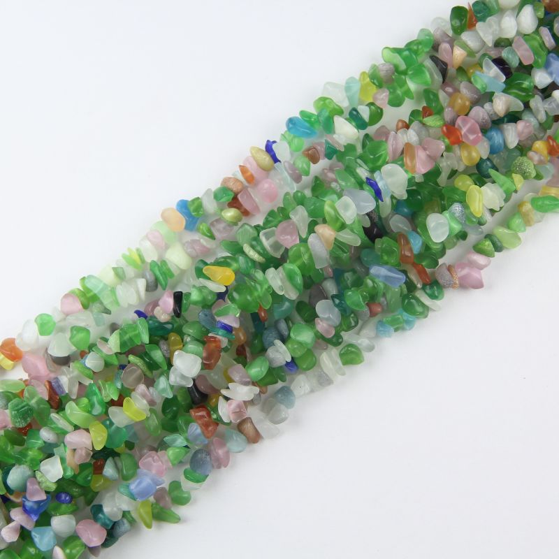 Multiple cat's eye glass long necklaces stacked together, showing pastel rainbow colors and moving light effect across all strands