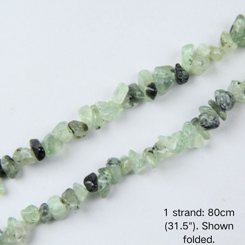 Close-up of 5-8mm pale green prehnite stone chips with natural black inclusions strung on nylon cord.