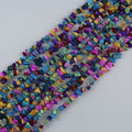 Irregular dyed howlite bead long necklace on white background, rainbow colored beads in turquoise, green, pink, purple, yellow and blue with natural black spiderweb matrix visible
