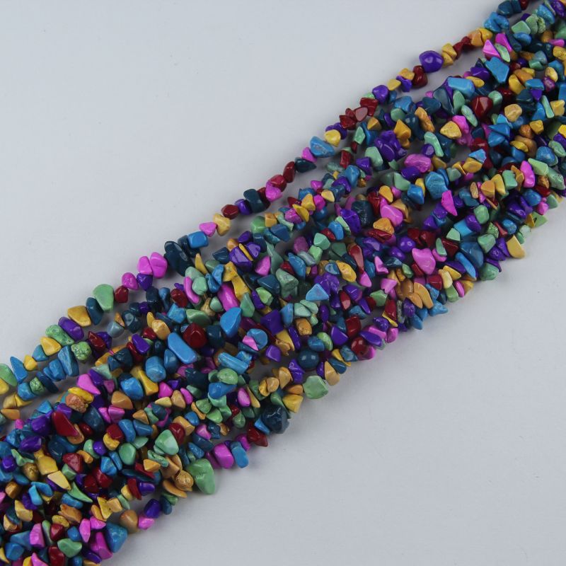 Multiple rainbow dyed howlite long necklaces stacked together, showing full spectrum of colors with authentic stone veining patterns