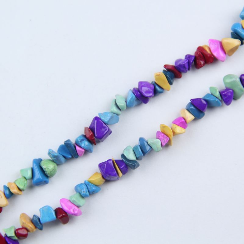 Close-up of dyed howlite beads showing vibrant rainbow colors and natural black spiderweb matrix veining, turquoise blue bead with authentic stone texture