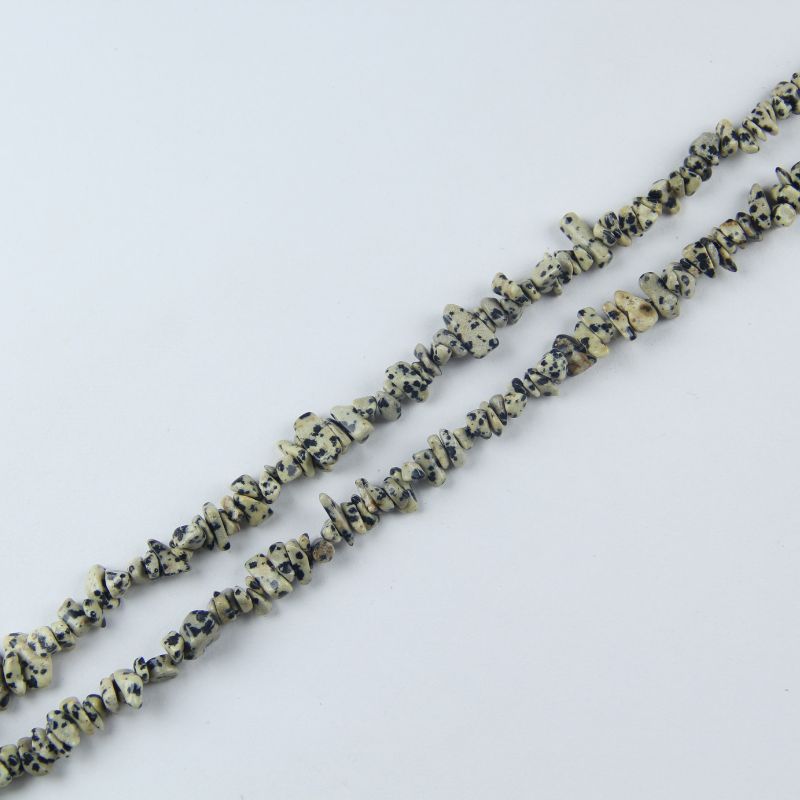 Flat lay of Dalmatian Jasper stone beads threaded on nylon cord, 31.5 inch length