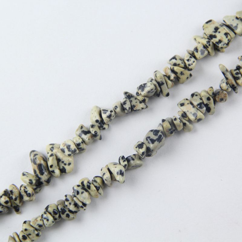 Close-up of irregular Dalmatian Jasper stone texture with natural black spots and nylon cord