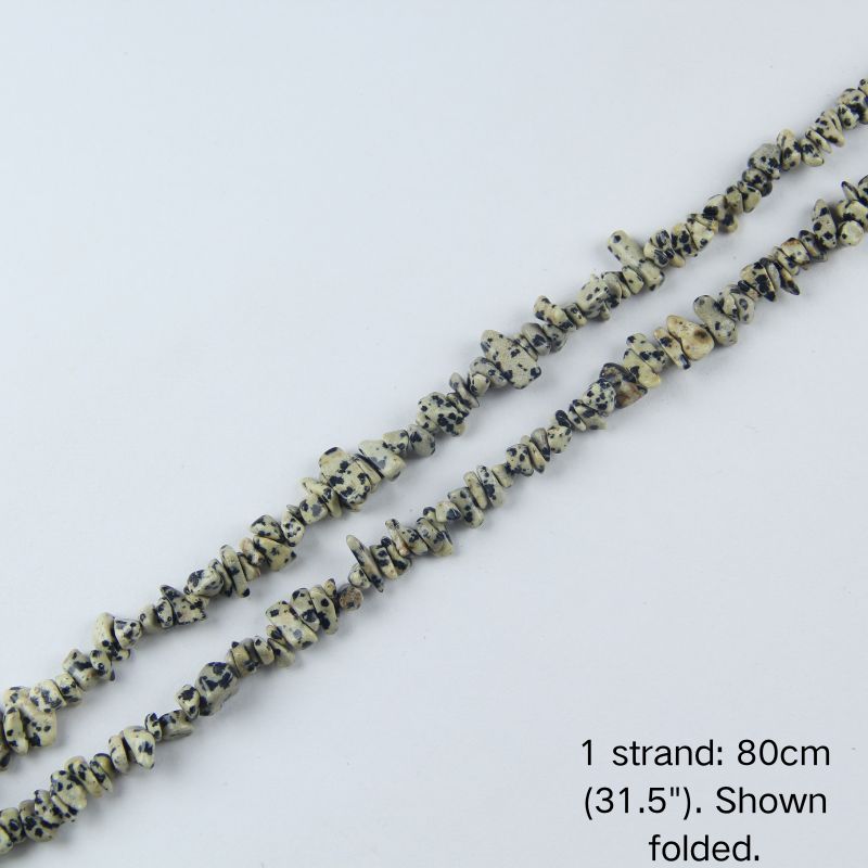 Dalmatian stone chip beaded strand, 31.5 inch (80cm) length shown folded on white background.