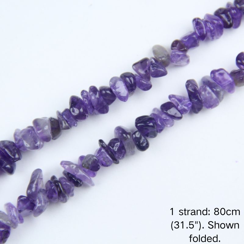 Macro close-up of glossy, richly colored Deep Amethyst irregular crystal chip beads, showing deep purple hues, polished texture, and center-drilled holes.
