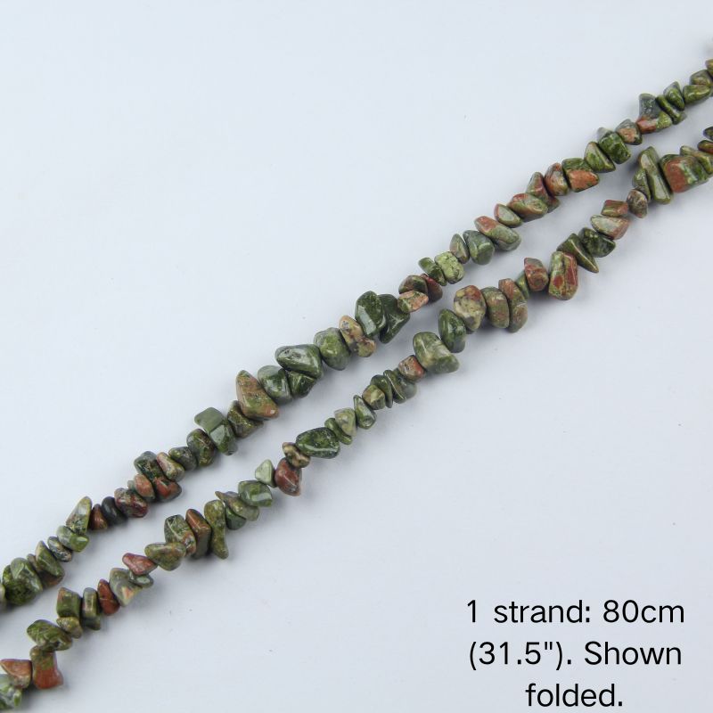 Dyed spiderweb turquoise color howlite chip beads strand folded, 31.5 inches, nylon cord, vibrant blue-green with dark web pattern.