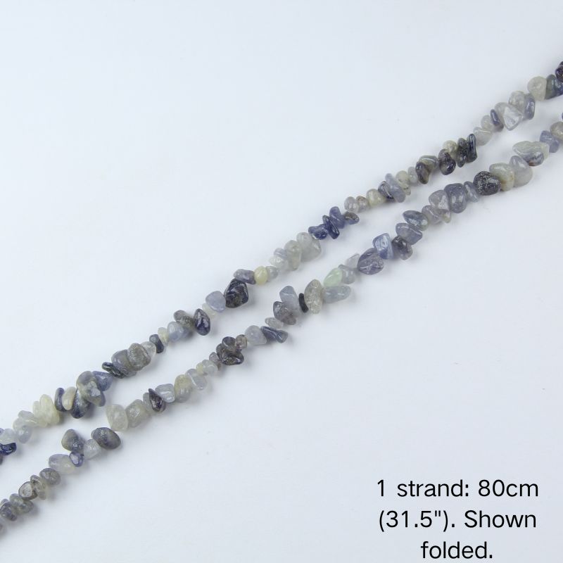 Single strand of Iolite crushed stones folded in a curve on white background, pre-strung on nylon thread