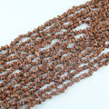 Irregular gold sandstone chip bead long necklace on white background, warm golden brown glass beads with thousands of tiny copper sparkle particles visible