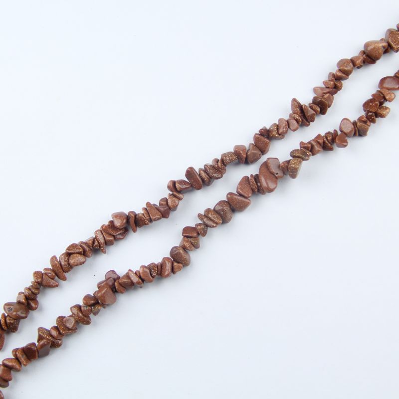 Single irregular gold sandstone chip bead necklace laid flat on light surface, 31-inch strand with organic chip-shaped beads