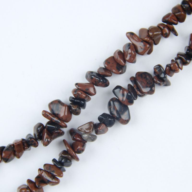 closeup of irregular golden swan obsidian beads lined up showing 5 to 8mm size variation and uniform gold sheen distribution on each bead