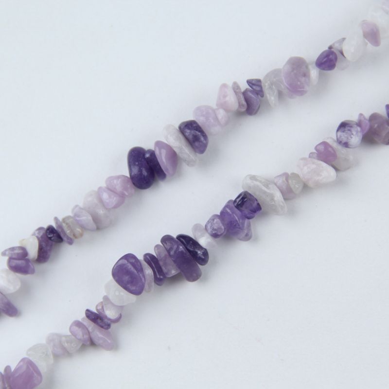 close-up of lilac crystal irregular round beads showing soft pale purple color and nylon cord stringing, 5-8mm size