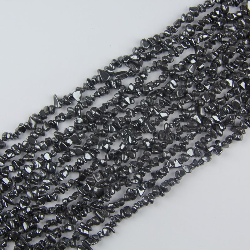 Natural iron stone chip bead strand 31.5 inches long on white background, gray-black 5-8mm irregular magnetic hematite chips with metallic luster strung on nylon cord
