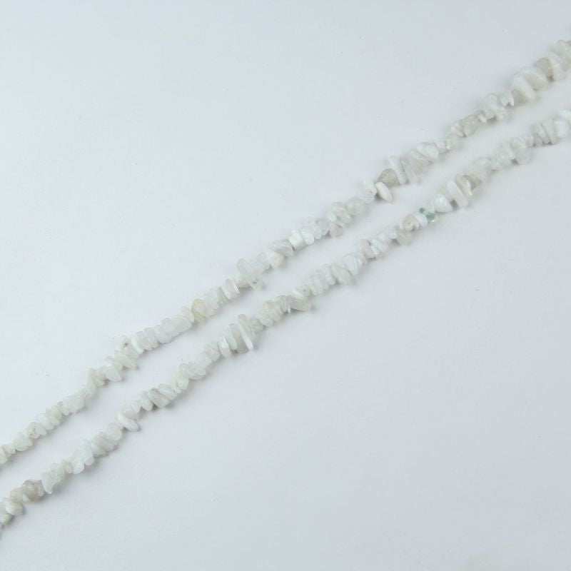 Close up of natural white moonstone chip bead strand, 31.5 inch length, irregular 5-8mm chips with adularescence glow, strung on nylon cord