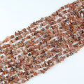 Natural red agate irregular bead long necklace on white background, deep red to crimson colors on each freeform round bead