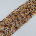 Natural yellow agate irregular bead long necklace on white background, honey yellow to golden amber colors on each freeform round bead