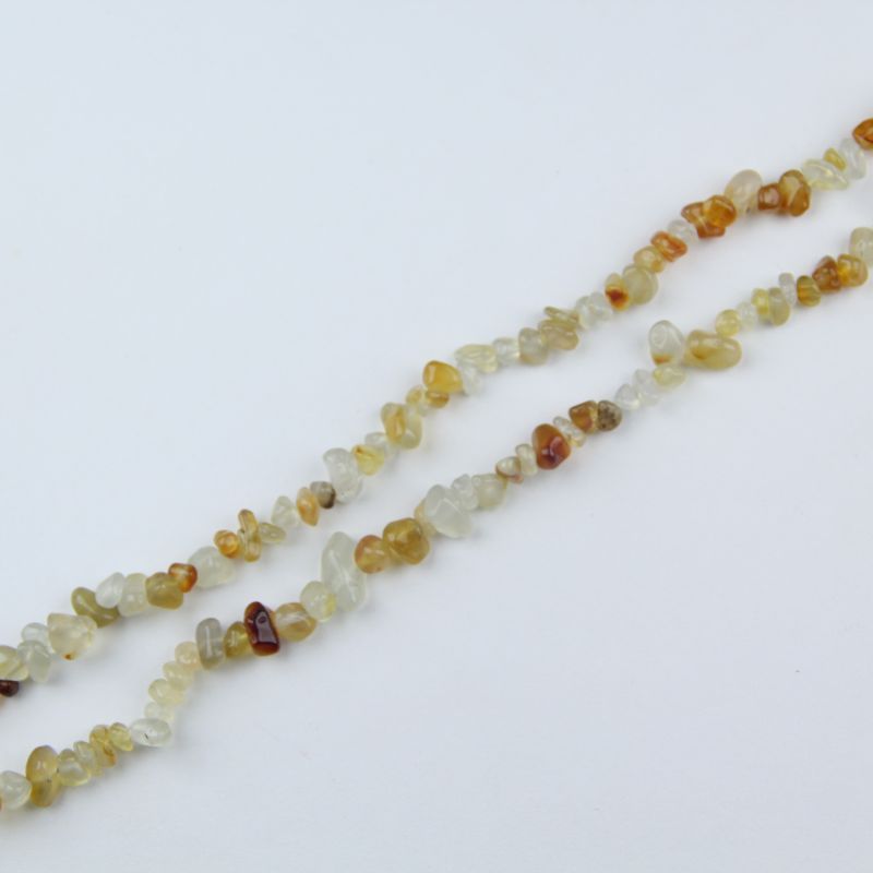 Single orange agate irregular round bead bracelet laid flat on natural linen, visible stretch cord and organic bead shapes
