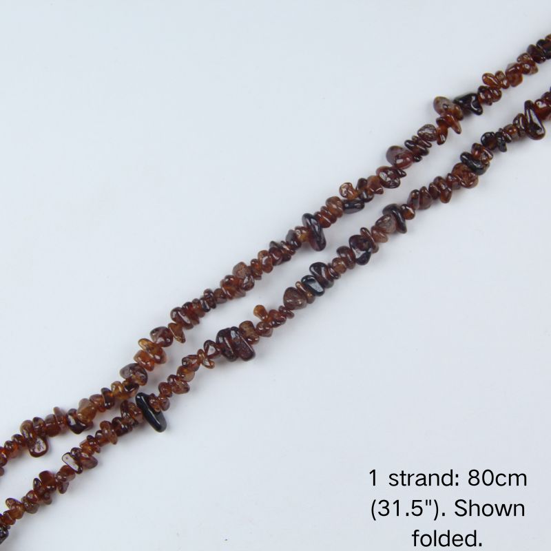 Orange garnet chip beaded strand, 31.5 inch (80cm) length shown folded on white background.