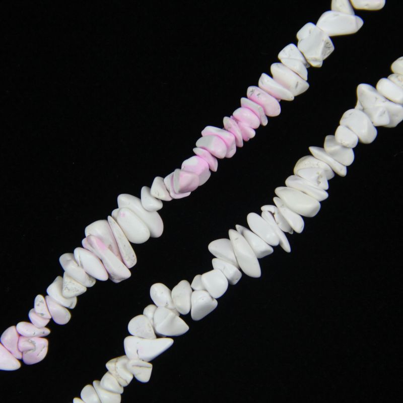 close-up of pink and white blossom howlite irregular round beads showing creamy white base and delicate pink crackled veining with nylon cord stringing, 5-8mm size