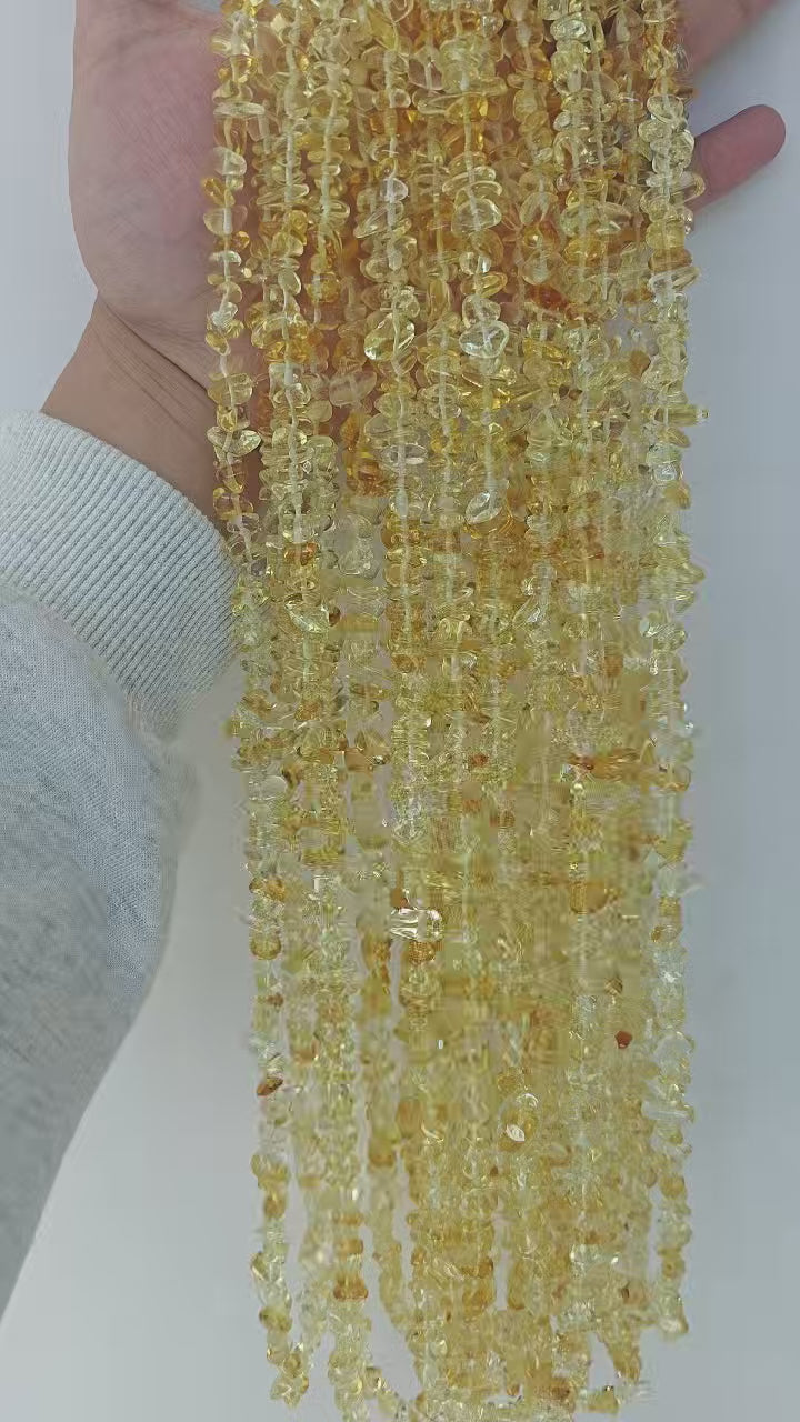 Close-up showcase of sunny yellow glass statement necklace. Highlights the sparkling finish and unique irregular shape of 5-8mm round yellow glass beads. 