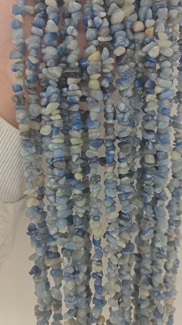 Close up showcase of natural blue aventurine long necklace. Shows sparkling inclusions in cool tone blue gemstone beads and how it matches with daily outfits. 