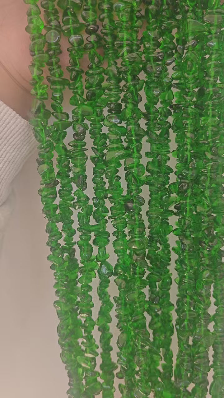 Wearing demonstration of handmade green glass long necklace. Rotates to show the glossy surface and natural inclusions of 5-8mm irregular green glass beads. 