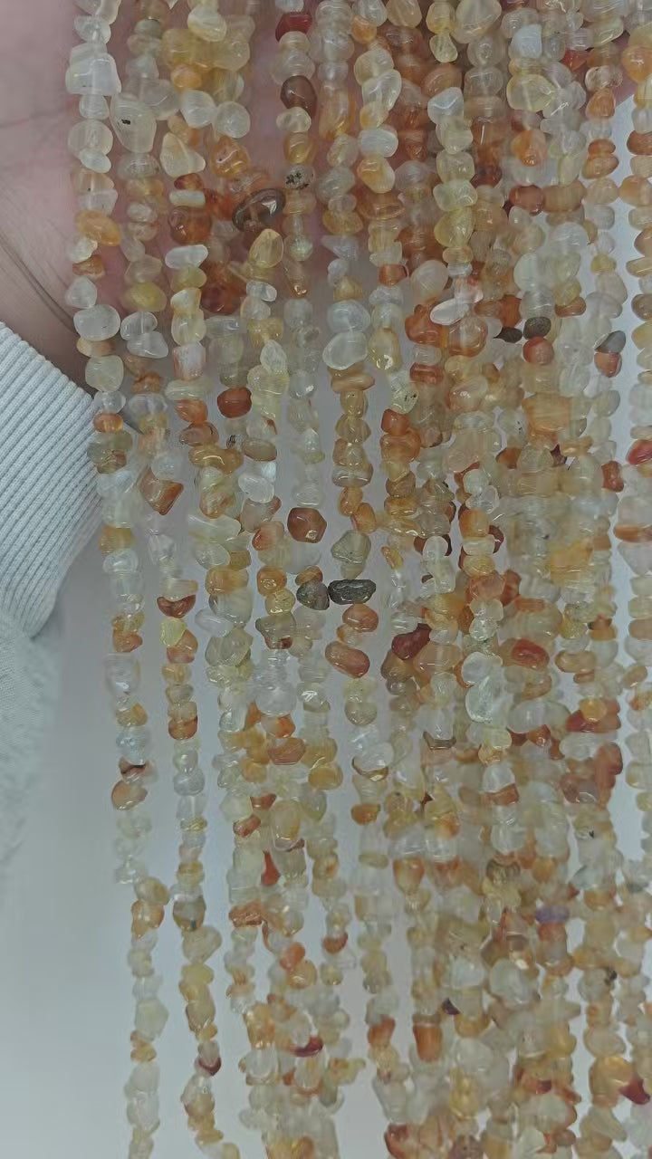 Stacked multiple orange agate irregular bracelets side by side, demonstrating color variation and bead size differences across different pieces