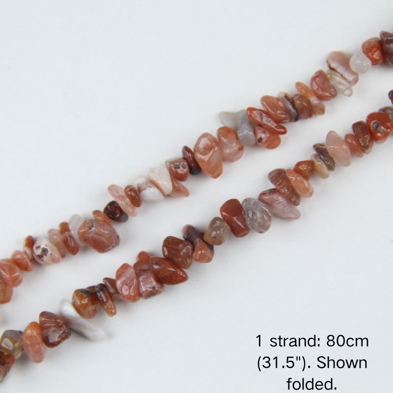 Macro close-up of glossy Red Agate 5-8mm irregular chip beads, showing polished surface, natural banding, translucency, and center-drilled holes for threading.