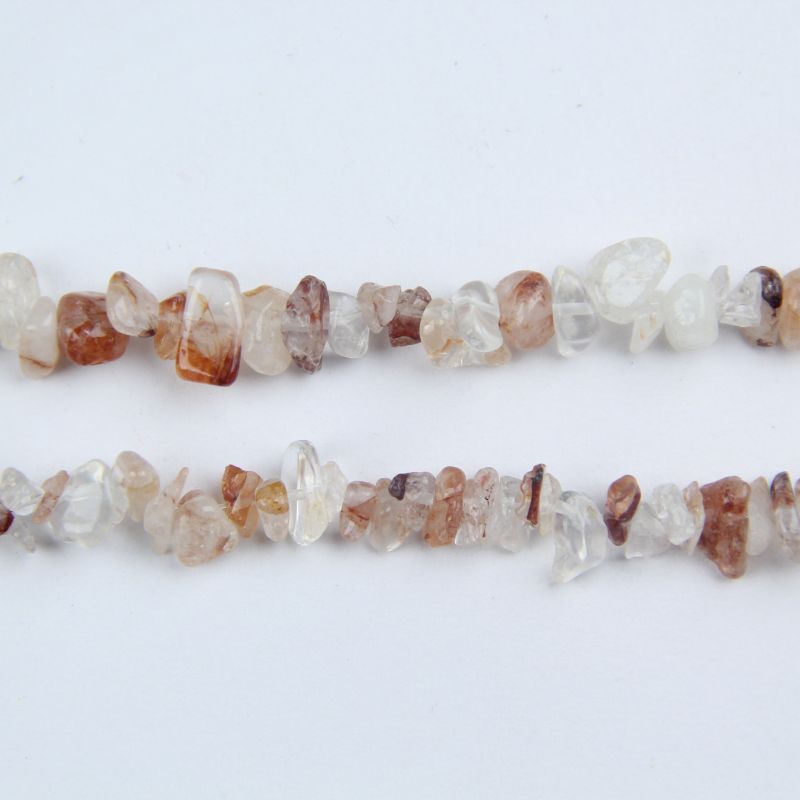 macro closeup of red floral inclusion quartz bead showing flower-like red inclusions suspended in clear crystal