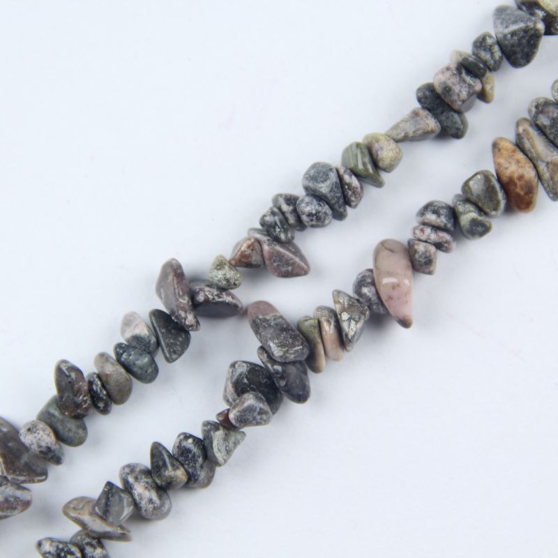Close-up of red stripe agate beads, showing natural pink and red concentric wave patterns on each irregular round bead