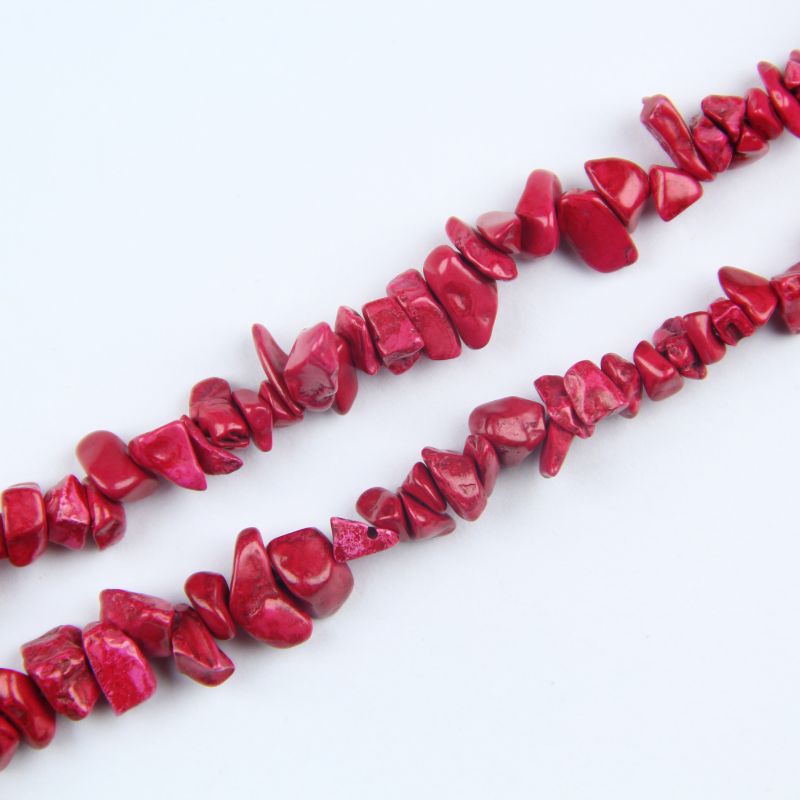 close-up of red turquoise irregular round beads showing rich brick-red color and natural veining with nylon cord stringing, 5-8mm size