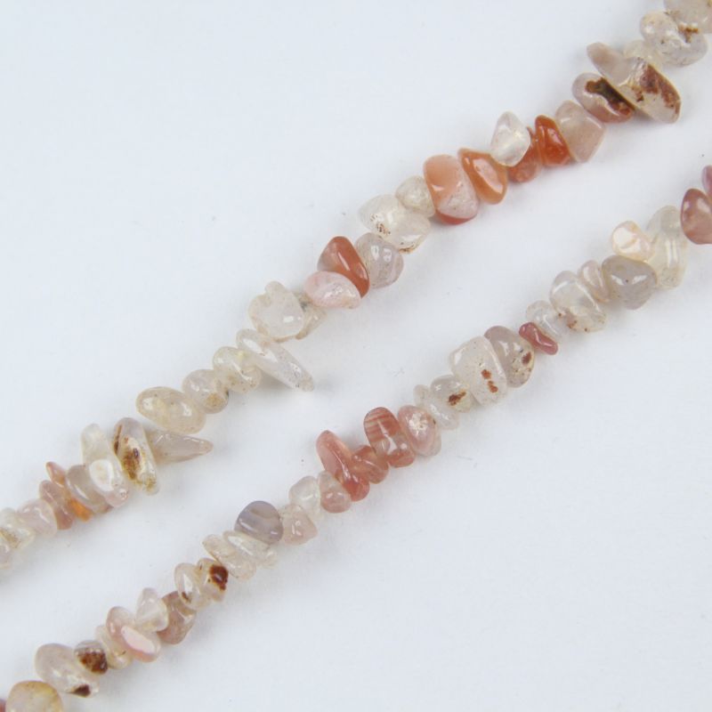 Close-up of red and white agate beads, alternating red and cream natural stripes on each irregular round bead