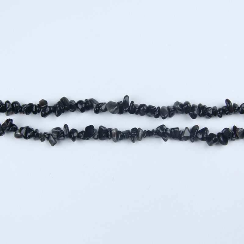 31.5 inch silver obsidian irregular bead necklace laid flat on white background showing subtle metallic silver sheen on black stone
