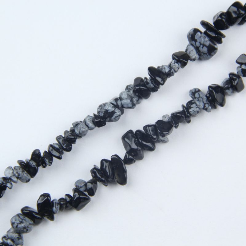 closeup of snowflake obsidian bead showing white snowflake crystal pattern on black volcanic glass