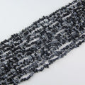 31.5 inch snowflake obsidian irregular bead necklace laid flat on white background showing white snowflake patterns