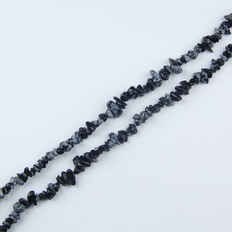 snowflake obsidian long bead chain hanging naturally against white background