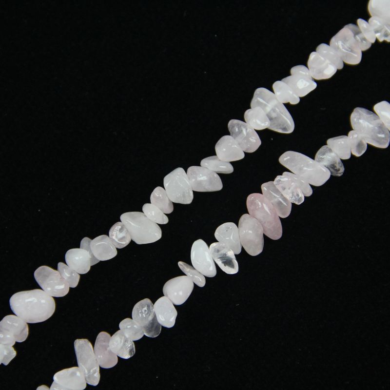 close-up of starry pink moissanite irregular round beads showing rainbow dispersion and nylon cord stringing, 5-8mm size