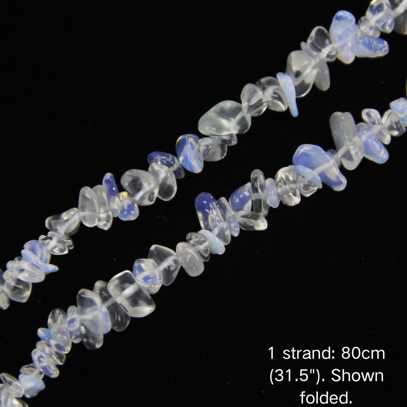 Macro close-up of luminous Synthetic White-Blue Opal 5-8mm chips, showing polished texture and center-drilled holes.