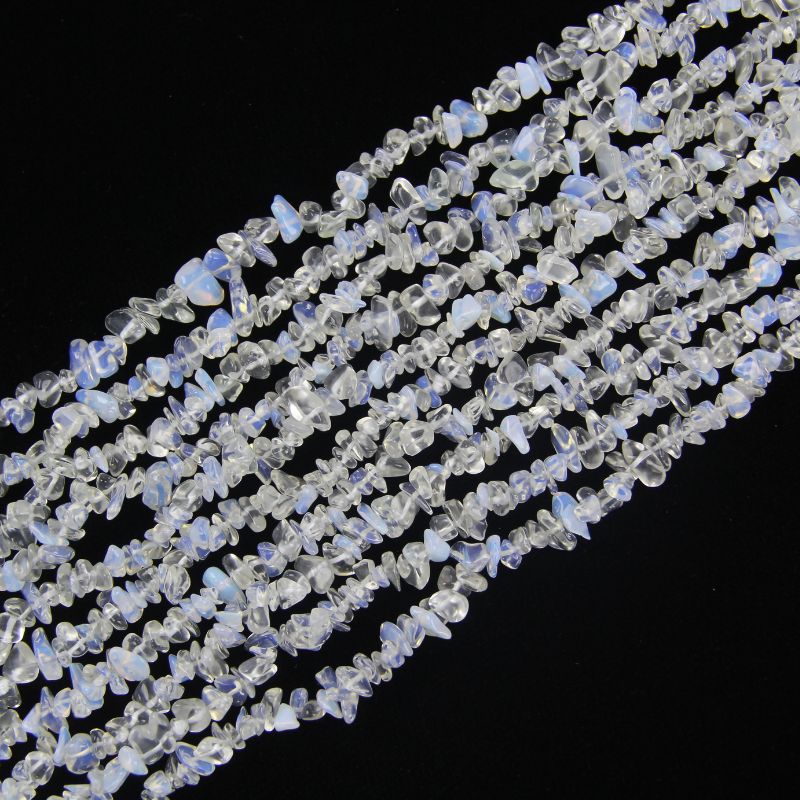 Irregular white blue opalite long necklace on white background, milky translucent glass beads with soft opalescent glow from white to pale blue