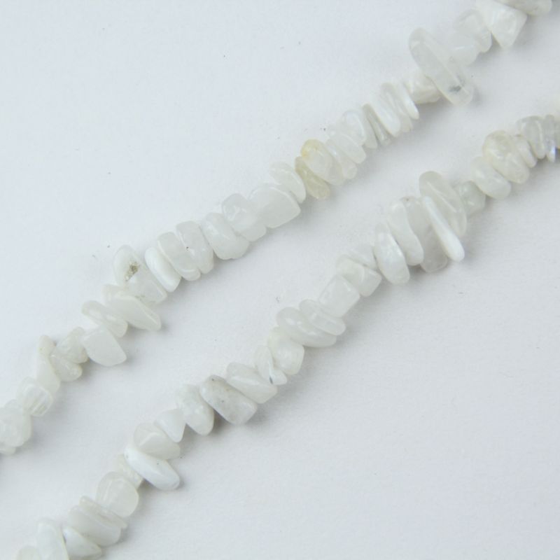 Macro close up of 5-8mm natural white moonstone chip beads, showing irregular organic shapes, adularescence and nylon cord stringing detail