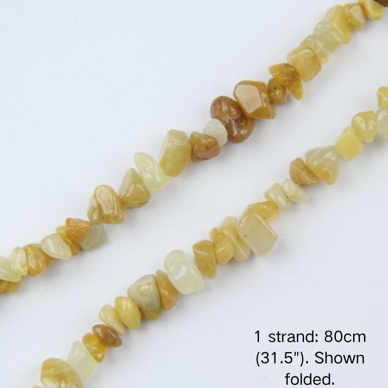 Macro close-up of glossy Yellow Aventurine 5-8mm irregular chip beads showing polished texture, translucency, and center-drilled holes.